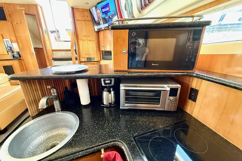 Slide: The Image of 2001 Carver 444 Cockpit Motor Yacht kitchen with sink, microwave, and appliances. - 30