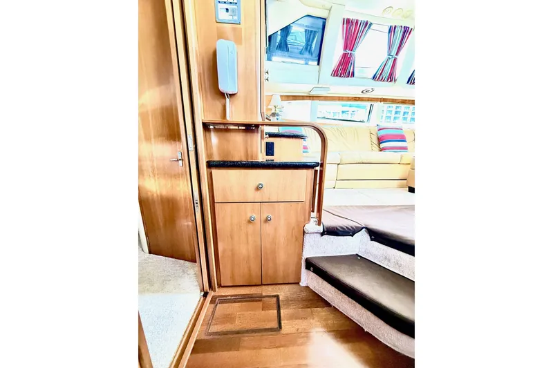 Slide: The Image of Interior of 2001 Carver 444 Cockpit Motor Yacht with wooden cabinetry and cozy seating area. - 31