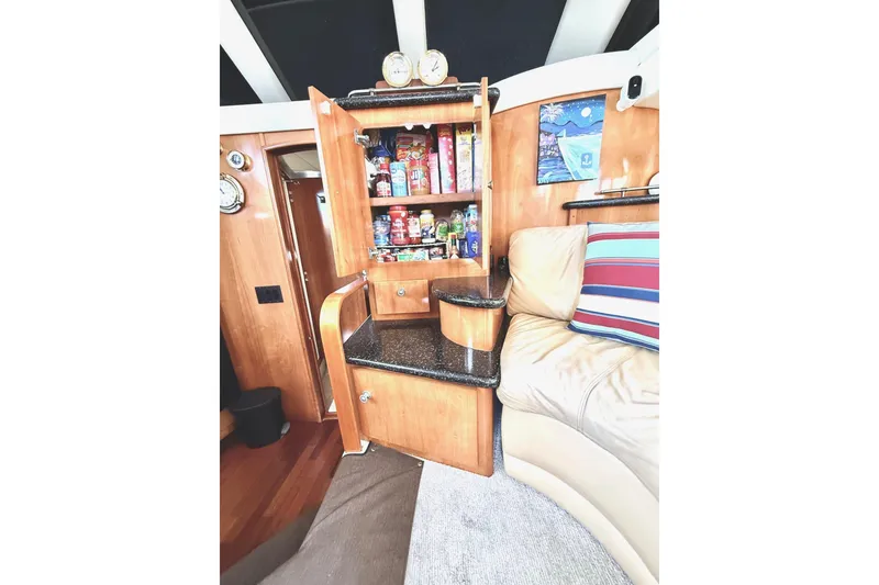 Slide: The Image of Interior of 2001 Carver 444 Cockpit Motor Yacht with open cabinet and cozy seating. - 32