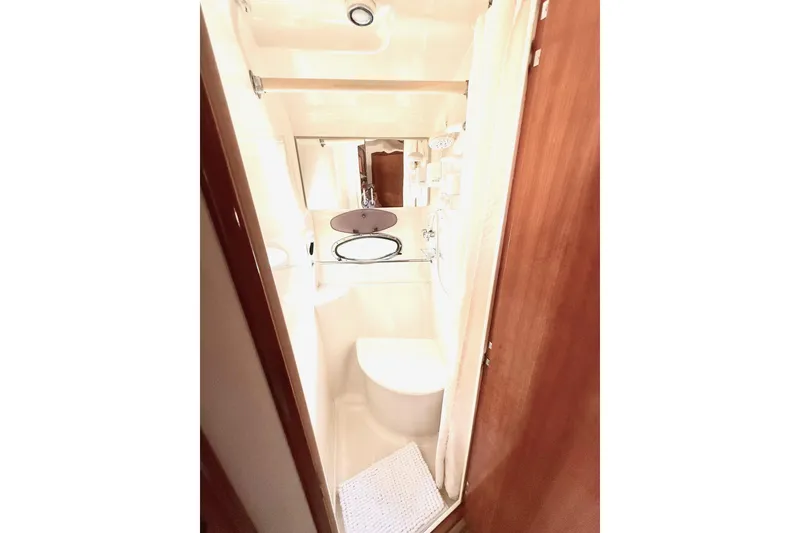 Slide: The Image of Compact bathroom in 2001 Carver 444 Cockpit Motor Yacht, featuring a toilet and mirror. - 38