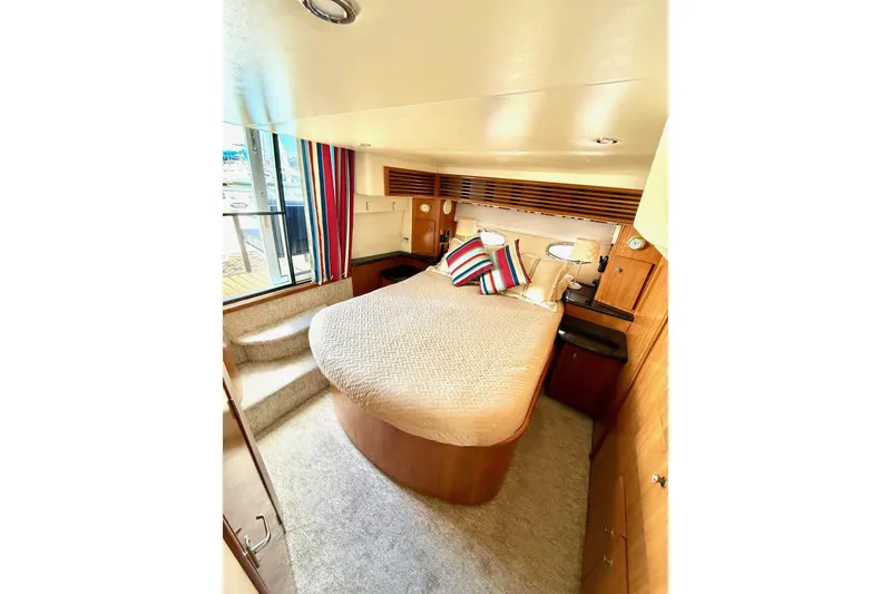 Slide: The Image of Luxurious bedroom in 2001 Carver 444 Cockpit Motor Yacht with cozy bed and striped pillows. - 42