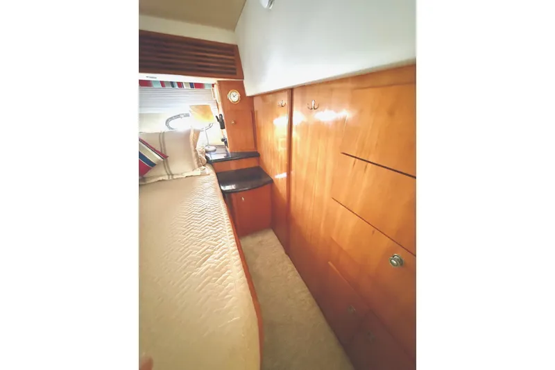 Slide: The Image of Interior of 2001 Carver 444 Cockpit Motor Yacht with wooden cabinetry and cozy bedding. - 44