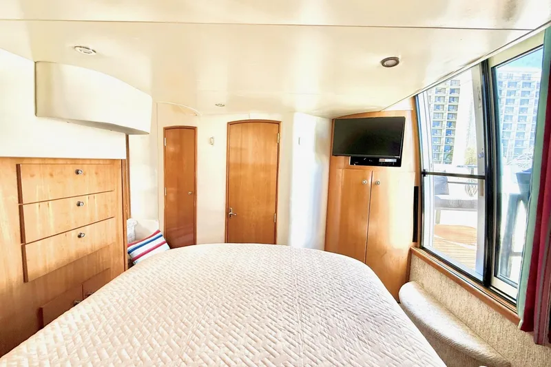 Slide: The Image of Luxurious 2001 Carver 444 Cockpit Motor Yacht bedroom with modern amenities and large windows. - 46
