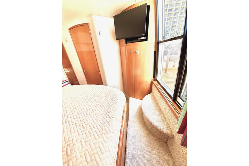 Slide: The Image of Interior of 2001 Carver 444 Cockpit Motor Yacht with bed, TV, and window view. - 52