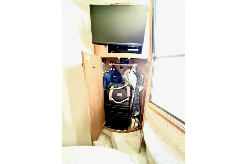 Slide: The Image of Closet in 2001 Carver 444 Cockpit Motor Yacht with TV and hanging clothes. - 53