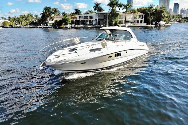 The Image of 2008 Sea Ray 38 Sundancer cruising on a sunny waterfront with palm trees. - 0