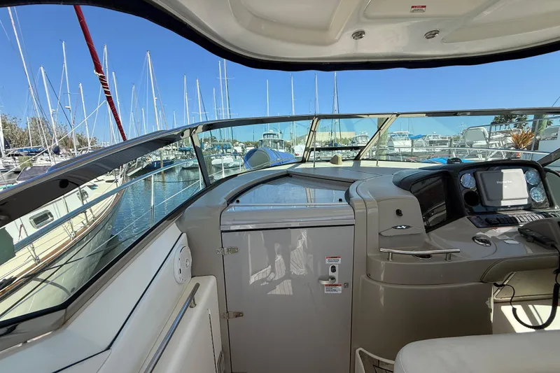 Slide: The Image of 2008 Sea Ray 38 Sundancer helm with marina view, showcasing navigation equipment and sleek design. - 102