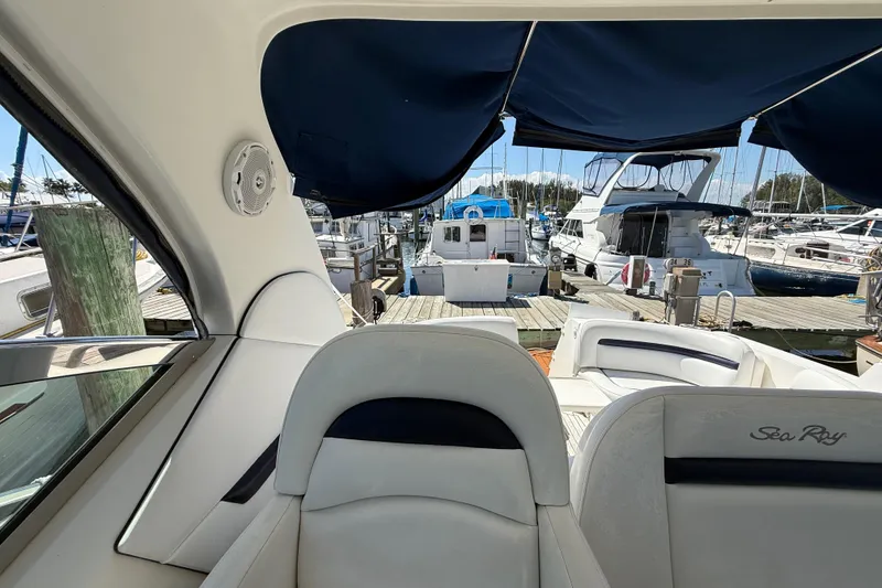 Slide: The Image of 2008 Sea Ray 38 Sundancer interior view at marina, showcasing luxury seating and docked boats. - 121