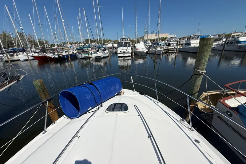 Slide: The Image of 2008 Sea Ray 38 Sundancer docked in a marina with sailboats and clear blue sky. - 14