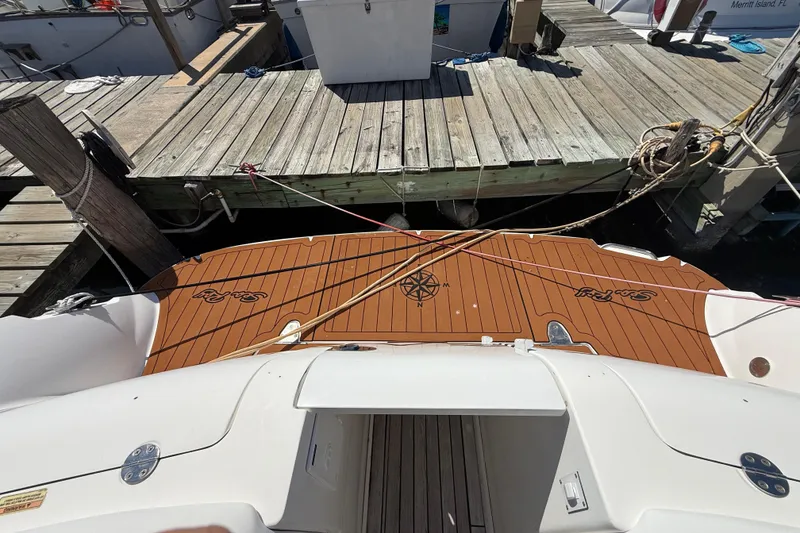 Slide: The Image of 2008 Sea Ray 38 Sundancer docked, showcasing teak swim platform and nautical compass design. - 142