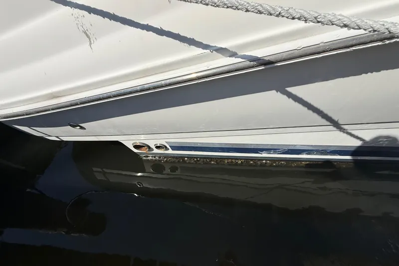 Slide: The Image of 2008 Sea Ray 38 Sundancer boat hull with visible waterline and docked ropes. - 29