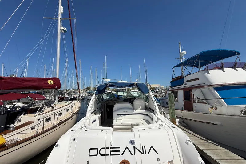 Slide: The Image of 2008 Sea Ray 38 Sundancer yacht docked at marina, surrounded by sailboats under clear blue sky. - 34