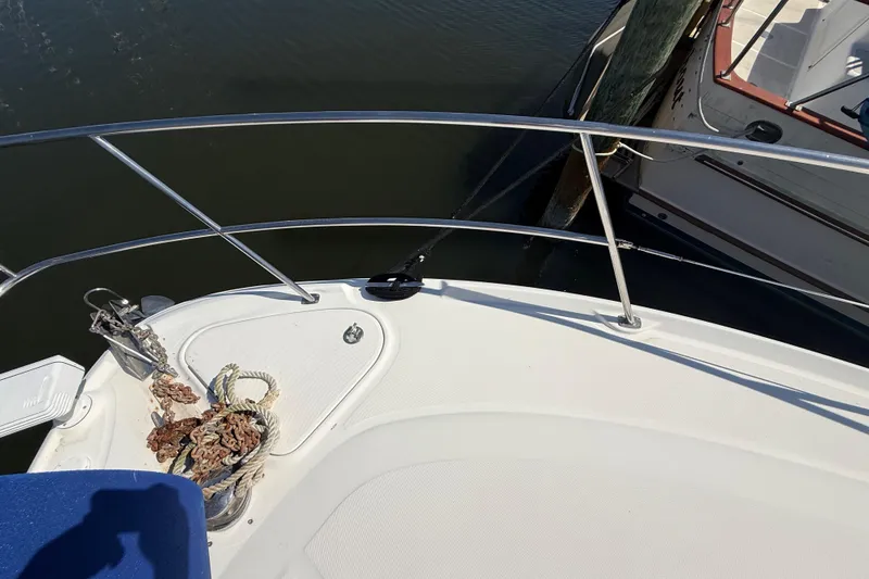Slide: The Image of 2008 Sea Ray 38 Sundancer bow with anchor and railing, docked beside another boat. - 4