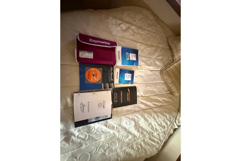 Slide: The Image of Manuals and guides for 2008 Sea Ray 38 Sundancer on a bed. - 46