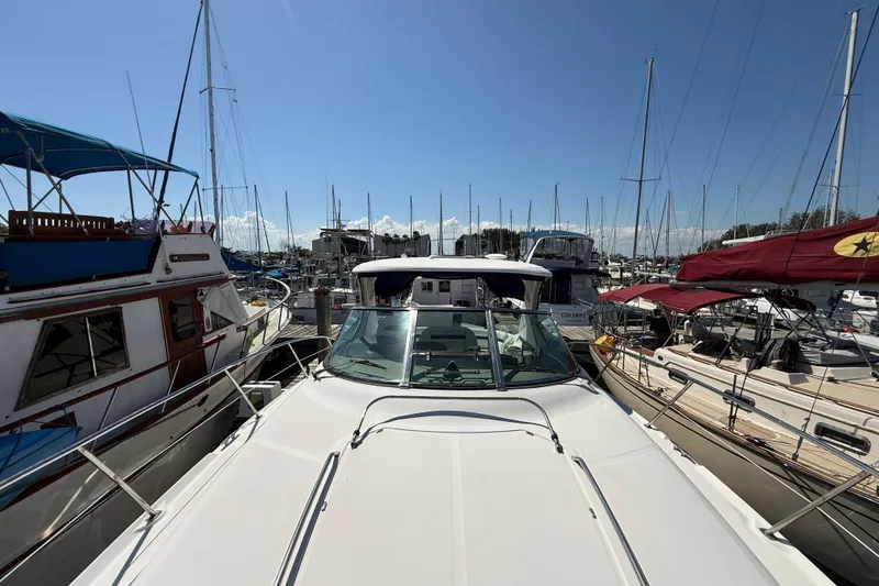 Slide: The Image of 2008 Sea Ray 38 Sundancer yacht docked in a marina, surrounded by sailboats. - 5