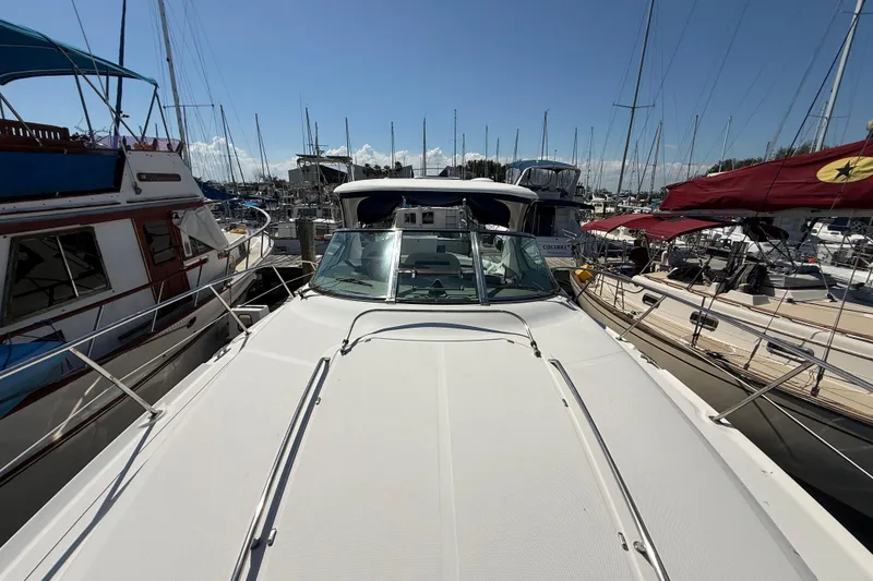 Slide: The Image of 2008 Sea Ray 38 Sundancer yacht docked at a marina, surrounded by other boats. - 6
