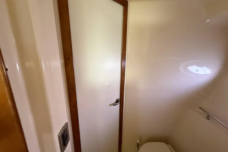 Slide: The Image of Interior of 2008 Sea Ray 38 Sundancer bathroom with wooden door and porthole. - 62