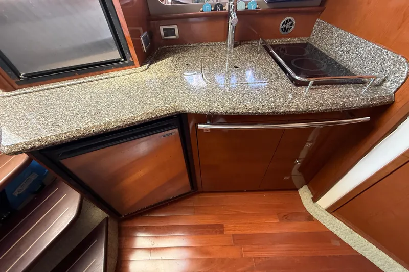 Slide: The Image of Luxurious 2008 Sea Ray 38 Sundancer yacht kitchen with granite countertops and wood cabinetry. - 64