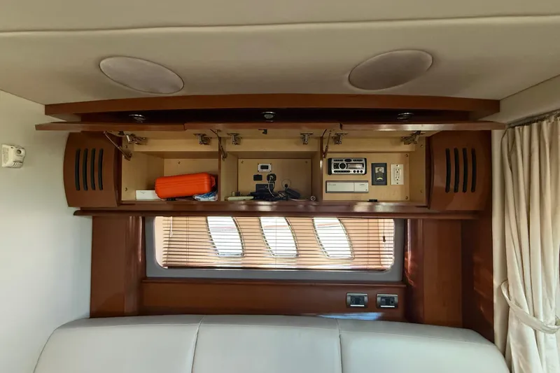 Slide: The Image of Interior of 2008 Sea Ray 38 Sundancer with open cabinet and electronic controls. - 77