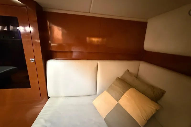 Slide: The Image of Interior cabin of 2008 Sea Ray 38 Sundancer with cushioned seating and pillows. - 83