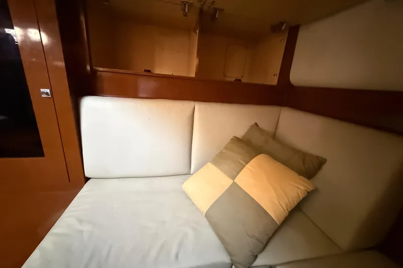 Slide: The Image of Interior of 2008 Sea Ray 38 Sundancer with beige seating and decorative pillows. - 84
