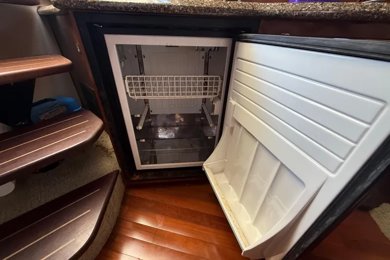 Slide: The Image of Open refrigerator inside 2008 Sea Ray 38 Sundancer yacht, showcasing interior storage space. - 96