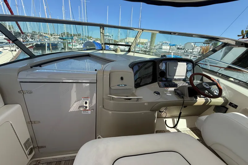 Slide: The Image of 2008 Sea Ray 38 Sundancer helm with steering wheel, navigation system, and marina view. - 99