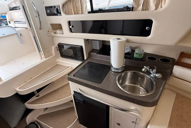 Slide: The Image of 2005 Grady-White Marlin 300 boat interior with kitchenette, sink, and microwave. - 20