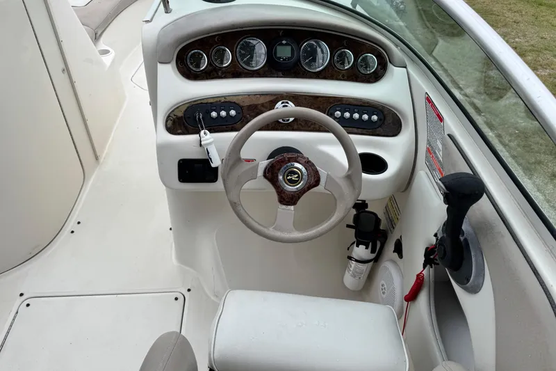 Slide: The Image of Steering console of a 2003 Sea Ray 240 Sundeck boat with gauges and controls. - 14