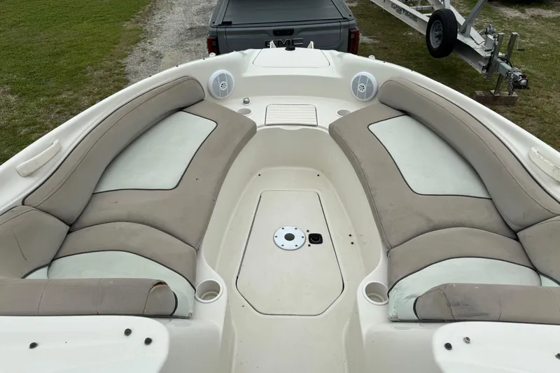 Slide: The Image of 2003 Sea Ray 240 Sundeck boat interior with cushioned seating and cup holders. - 16