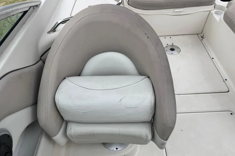 Slide: The Image of 2003 Sea Ray 240 Sundeck boat interior with cushioned seating and white deck. - 19