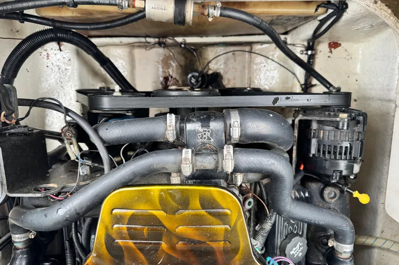 Slide: The Image of Engine compartment of a 2003 Sea Ray 240 Sundeck, showcasing hoses and components. - 21