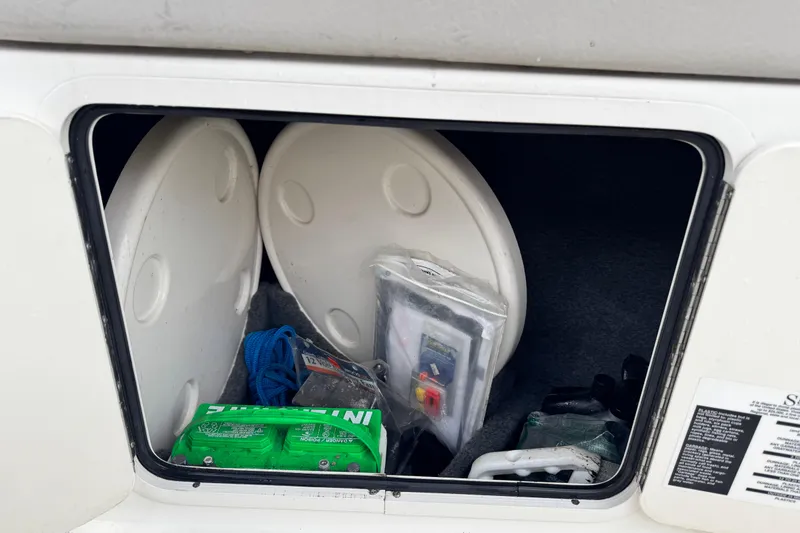 Slide: The Image of Storage compartment of a 2003 Sea Ray 240 Sundeck with boating accessories. - 23