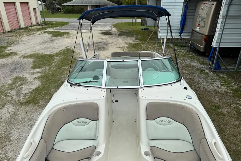 Slide: The Image of 2003 Sea Ray 240 Sundeck boat with blue canopy and spacious seating. - 27