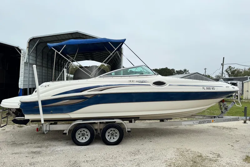 Slide: The Image of 2003 Sea Ray 240 Sundeck boat on trailer with blue canopy. - 4