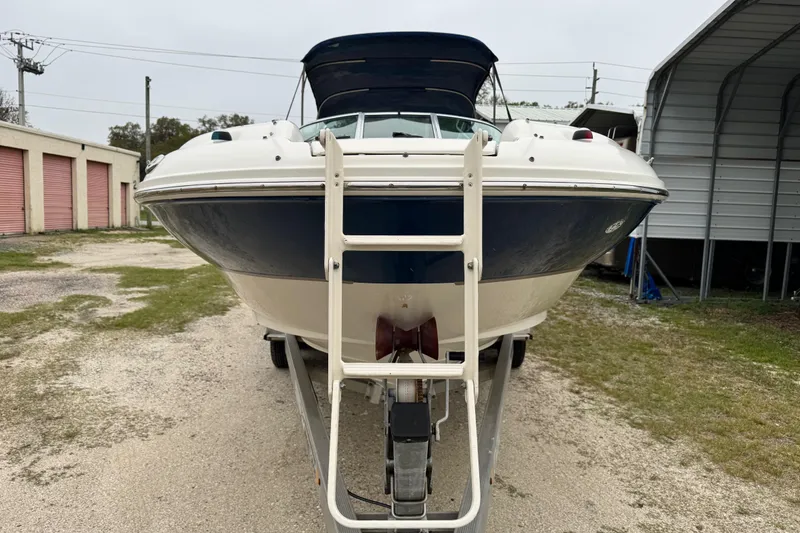Slide: The Image of 2003 Sea Ray 240 Sundeck boat on trailer, front view with ladder, parked outdoors. - 5