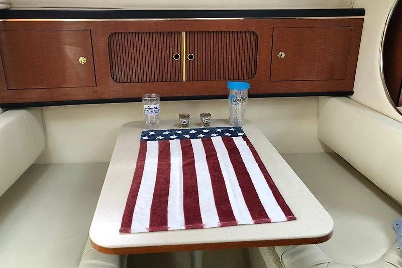 Slide: The Image of Interior of 2001 Sea Ray 290 Sundancer with American flag decor on table. - 6