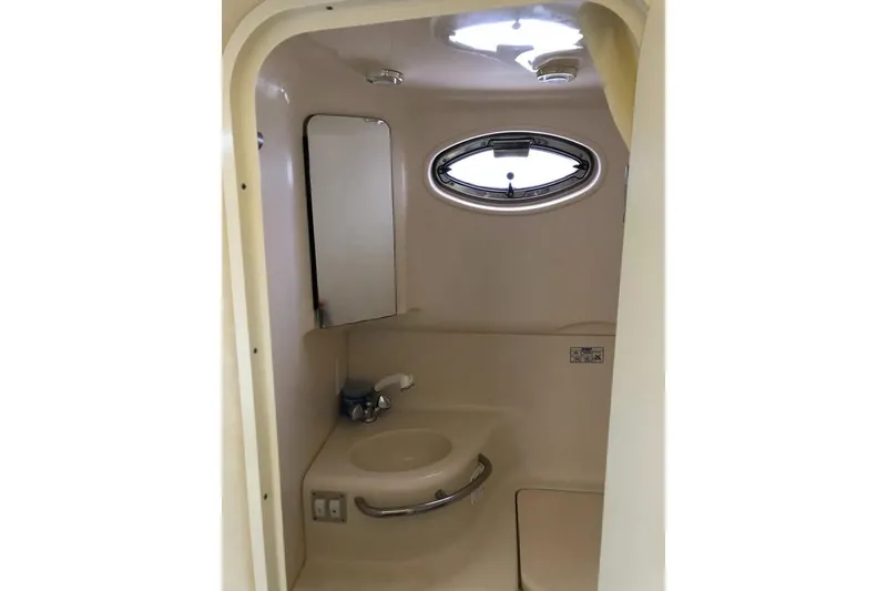 Slide: The Image of 2001 Sea Ray 290 Sundancer bathroom with sink, mirror, and oval window. - 8