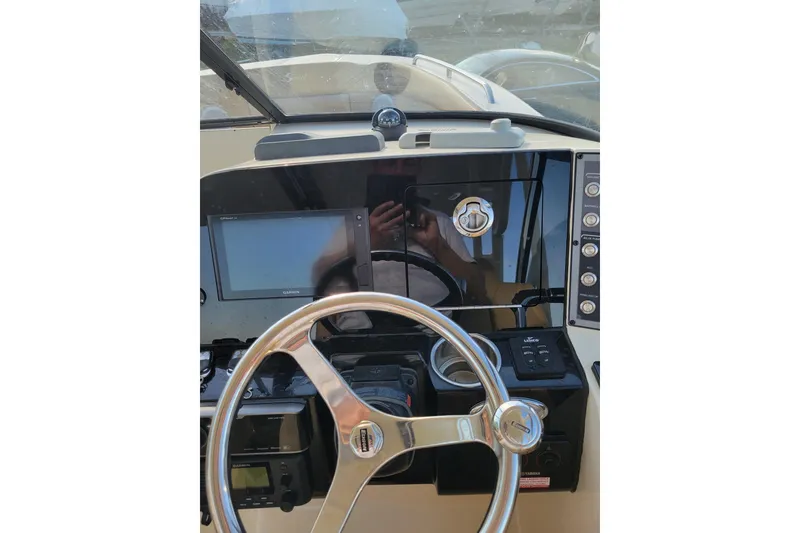 Slide: The Image of 2020 Scout 255 Dorado boat dashboard with steering wheel and navigation controls. - 13