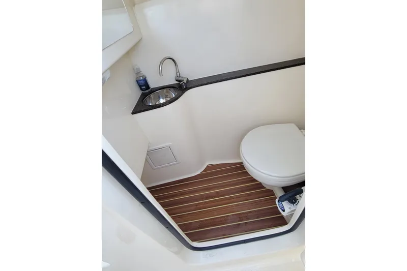 Slide: The Image of 2020 Scout 255 Dorado boat bathroom with sink, toilet, and wooden floor. - 19