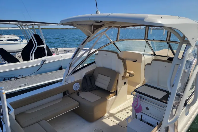 Slide: The Image of 2020 Scout 255 Dorado boat interior with seating, docked by the water. - 5