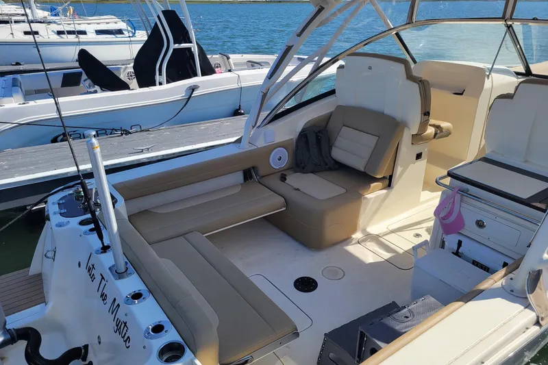 Slide: The Image of 2020 Scout 255 Dorado boat interior at marina, featuring seating and fishing equipment. - 8