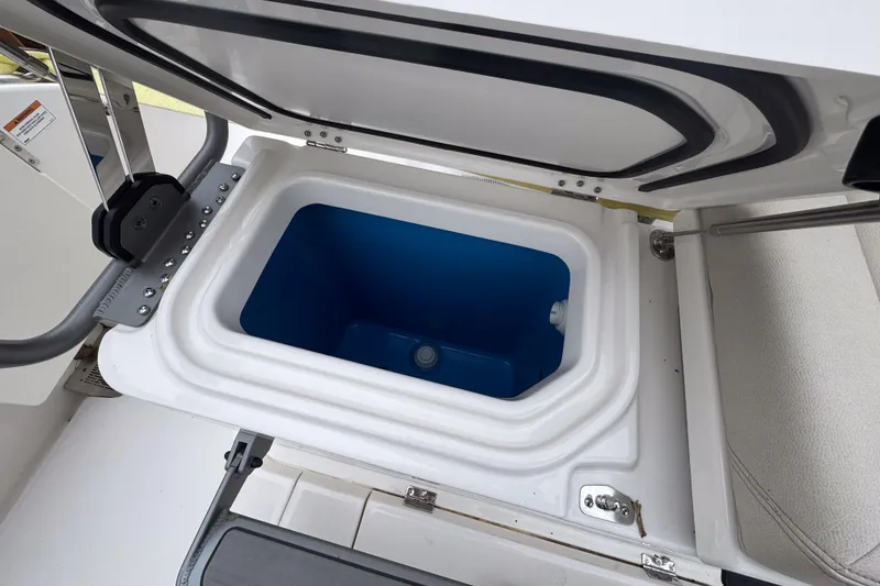 Slide: The Image of Open storage compartment on 2025 Solace 30 HCS boat, featuring a blue interior. - 21