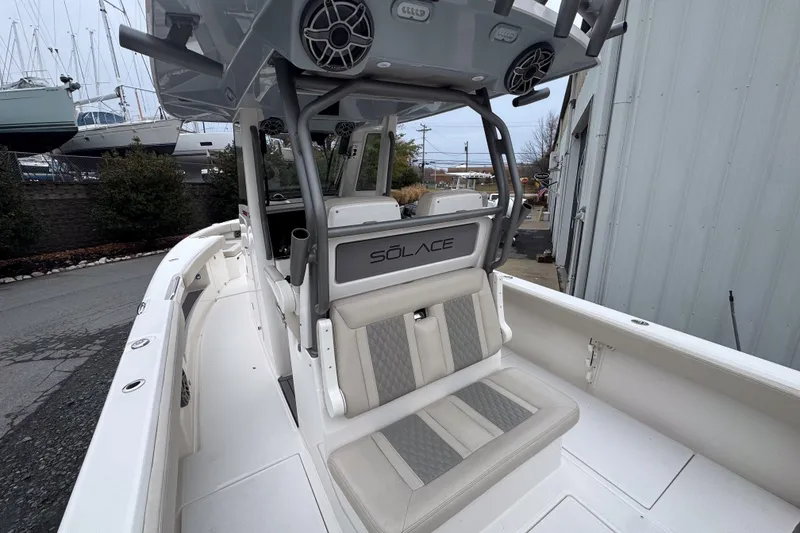 Slide: The Image of 2025 Solace 30 HCS boat interior with seating and console, docked near other vessels. - 5