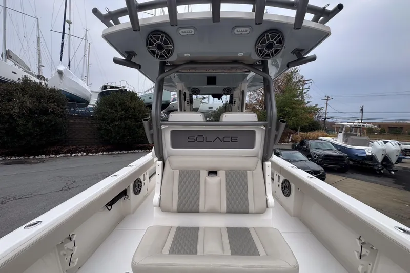 Slide: The Image of 2025 Solace 30 HCS boat interior with seating and speakers, docked near other boats. - 6