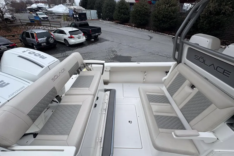 Slide: The Image of 2025 Solace 30 HCS boat interior with cushioned seating and Mercury engines. - 9