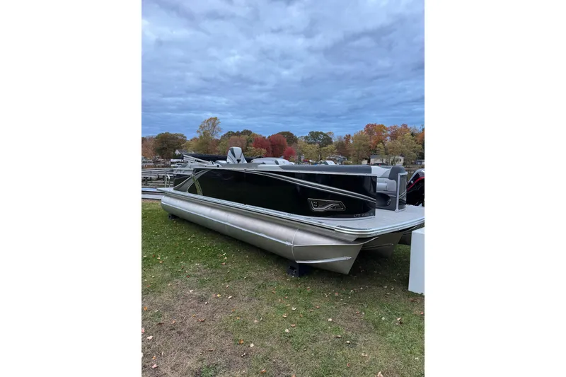 The Image of 2026 Tahoe Pontoon LTZ Quad Lounger 23 on grass with autumn trees in background. - 0