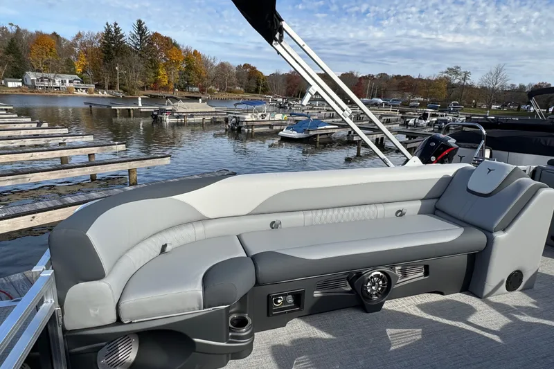 Slide: The Image of 2026 Tahoe Pontoon LTZ Quad Lounger 23 with gray seating at a lakeside dock. - 11