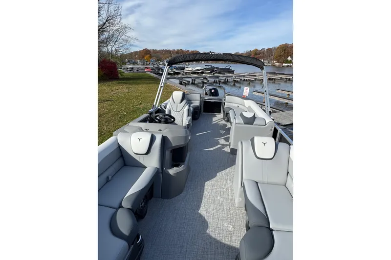 Slide: The Image of 2026 Tahoe Pontoon LTZ Quad Lounger 23 with spacious seating and modern design at a lakeside dock. - 13