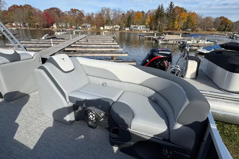 Slide: The Image of 2026 Tahoe Pontoon LTZ Quad Lounger 23 with gray seating, docked by a scenic lake. - 5